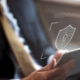 Side view of a man holding a smart tablet with a white lock graphic