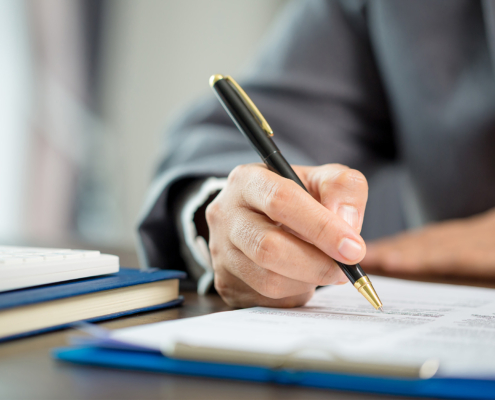 Side view of a person writing with fancy pen