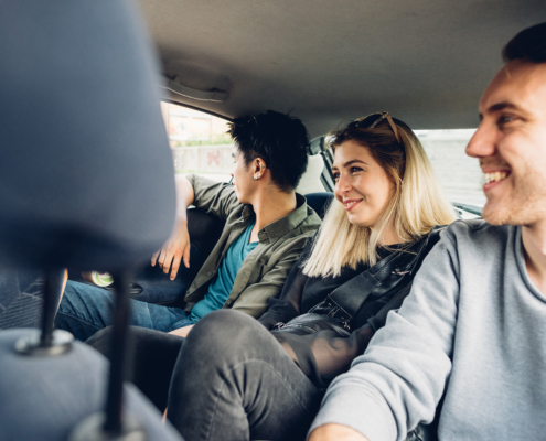 Side view of a group of friends riding in backseat of car together