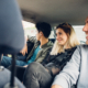 Side view of a group of friends riding in backseat of car together