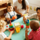 Nursery children playing with teacher in the classroom