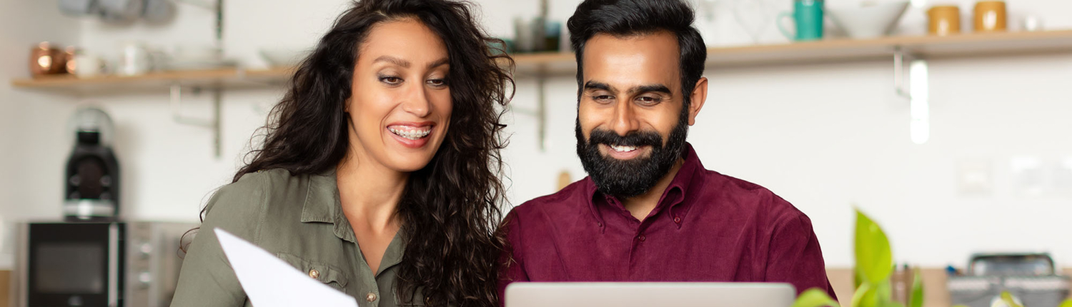 couple looking at computer in kitchen