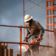 Construction worker wearing a hard hat operating a circular saw