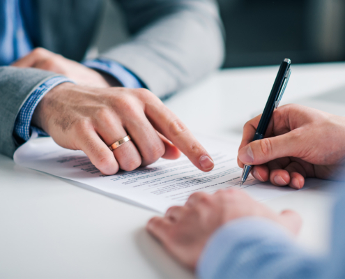Businessmen hand's pointing where to sign a contract, legal papers or application form