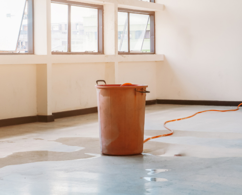 Large waste bucket being used to remove water
